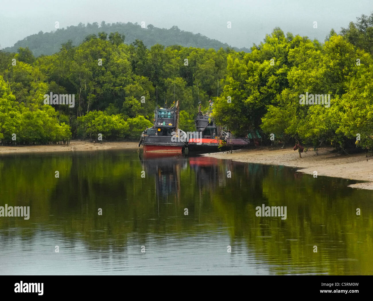 two boats moored in a channel in Thailand Stock Photo