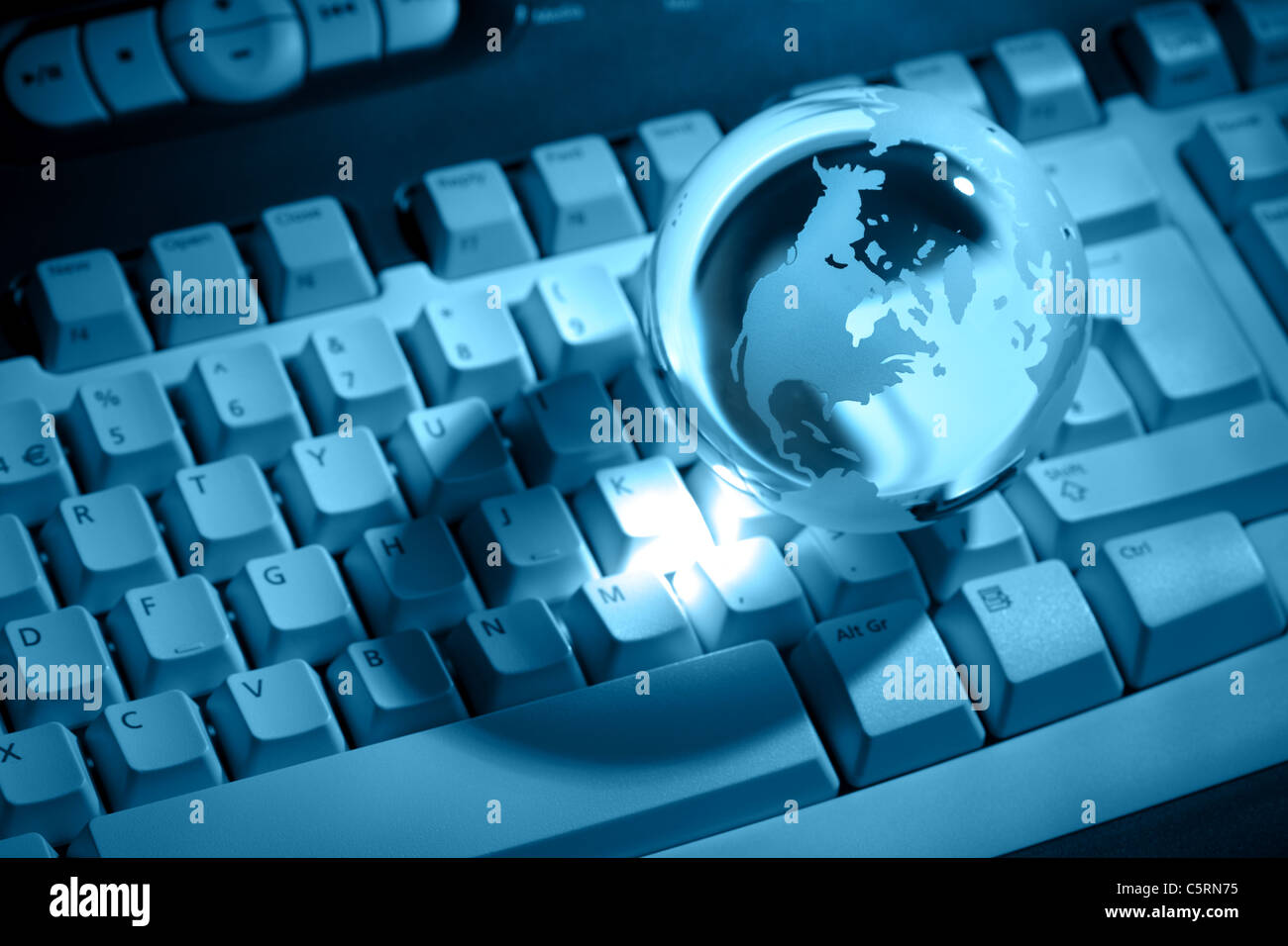 Crystal globe on keyboard Stock Photo