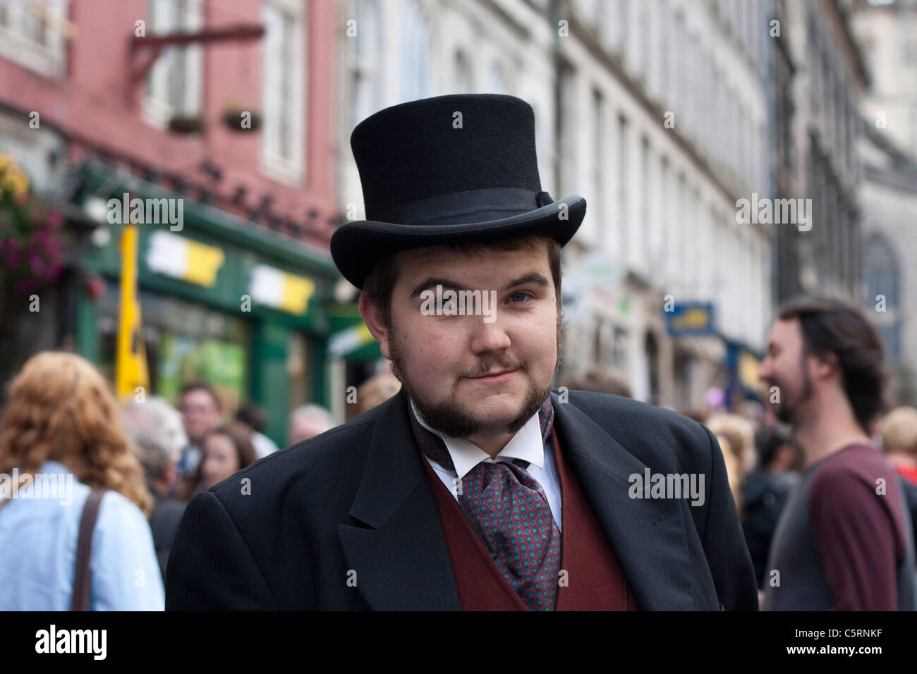 A man in Victorian dress stands on Edinburgh's Royal Mile to promote his show in the Fringe festival Stock Photo