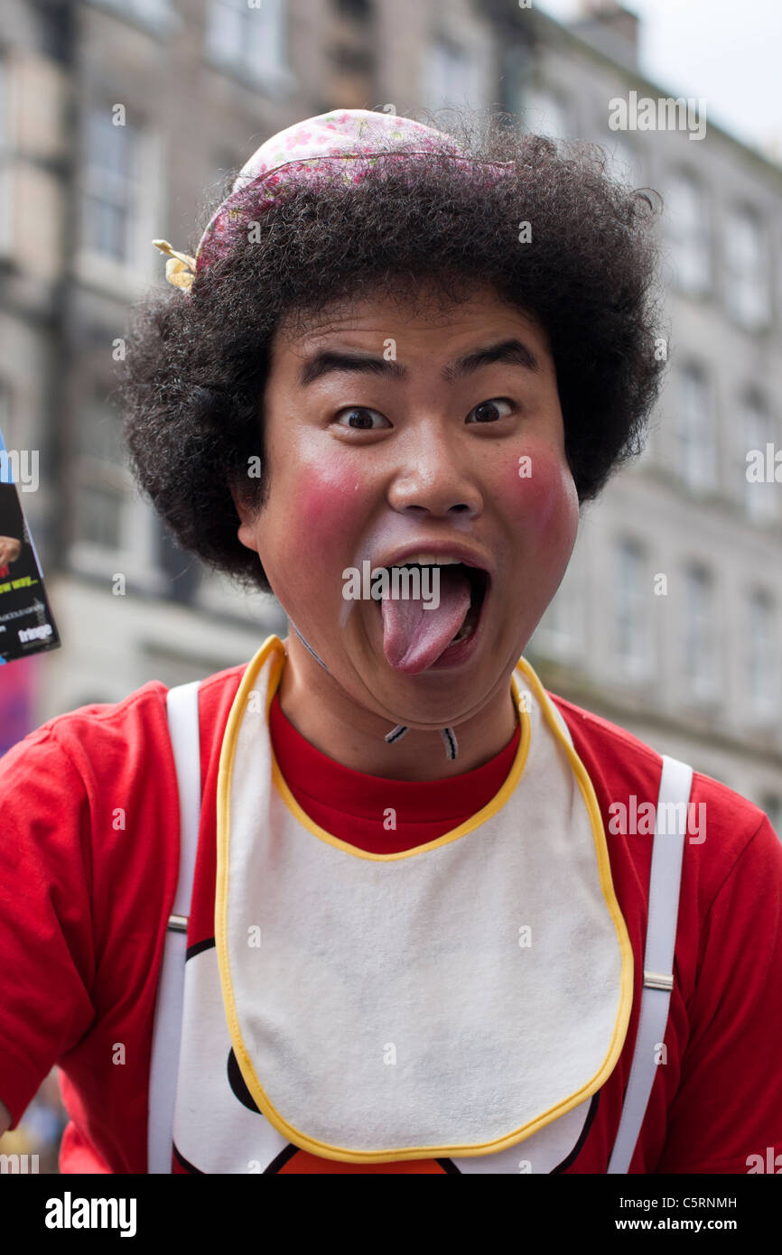 A Japanese performer on Edinburgh's Royal Mile strikes a pose to promote his act as part of the Fringe festival Stock Photo