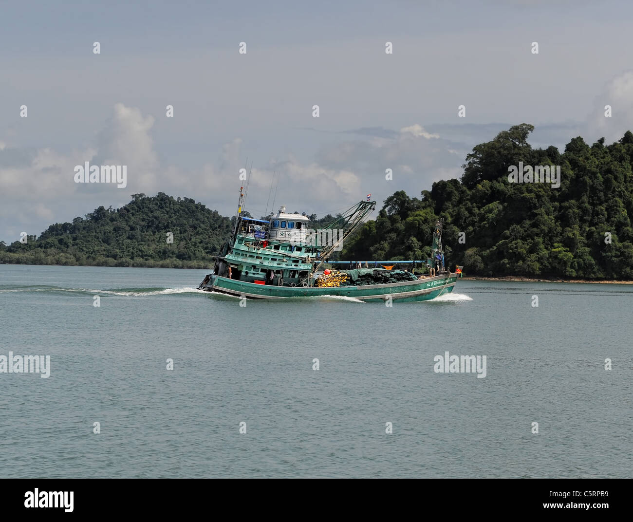fishing boat motoring into harbor in Thailand Stock Photo