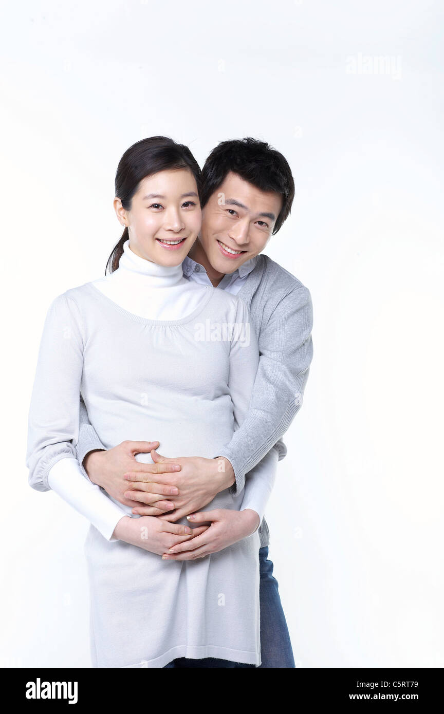 A man hugging his pregnant wife Stock Photo - Alamy