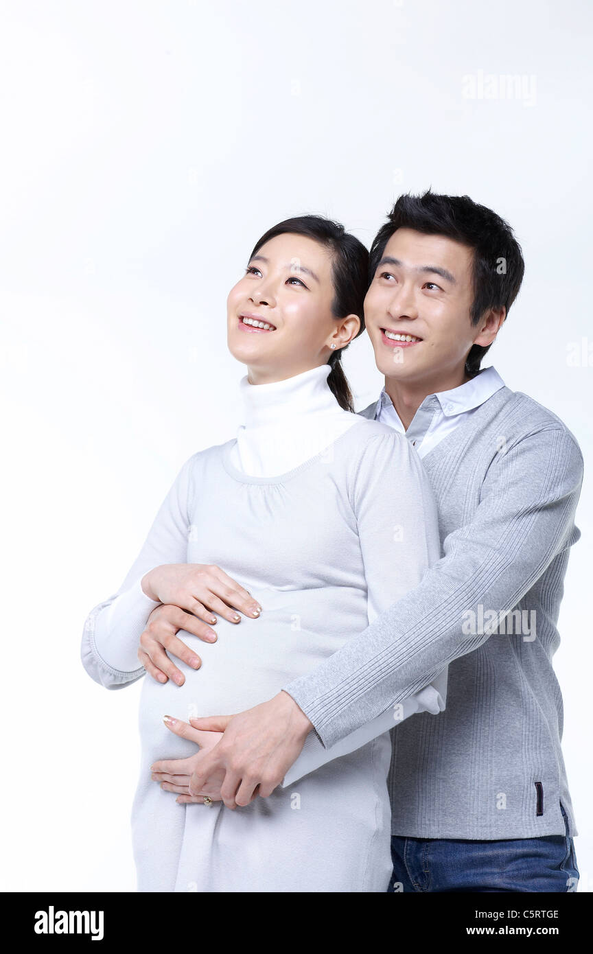 A man hugging his pregnant wife Stock Photo - Alamy