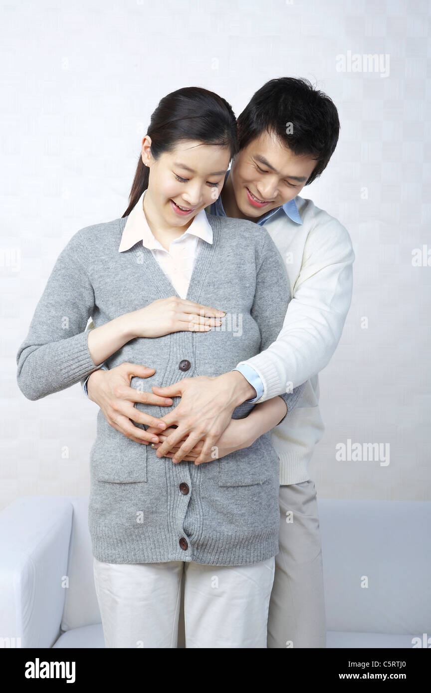 A man hugging his pregnant wife Stock Photo - Alamy