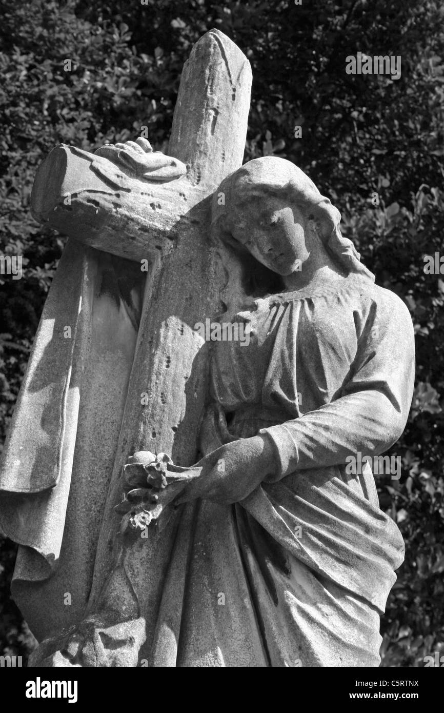 Gravestone Of Angel Holding Cross In Flaybrick Memorial Cemetery Gardens, Bidston Hill, The Wirral, Merseyside, England, UK Stock Photo