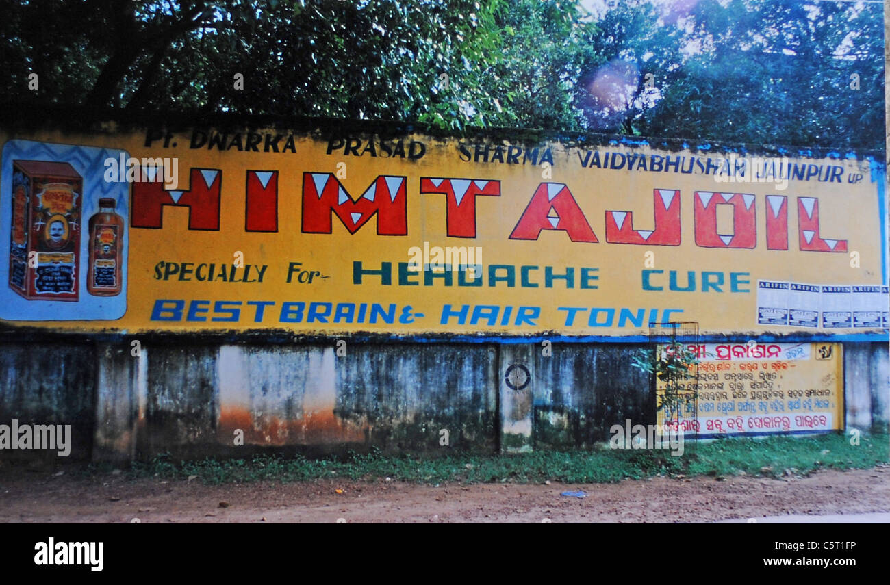 An amusing sign for headache cure and best brain and hair tonic in the city of Bhubaneswar in Orissa India himtajoil Stock Photo