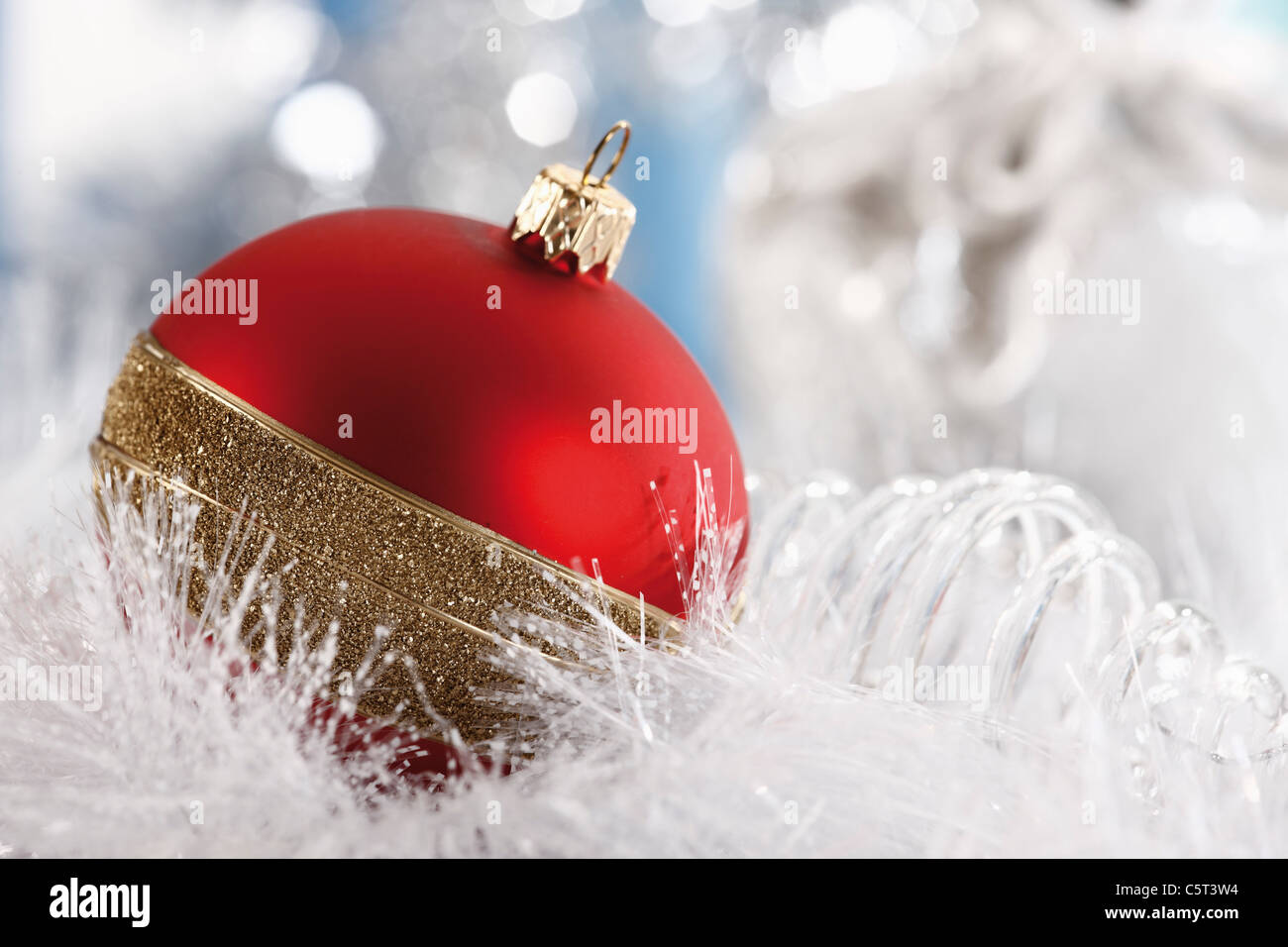 Christmas decoration, Red christmas bauble and white christmas garland, close-up Stock Photo