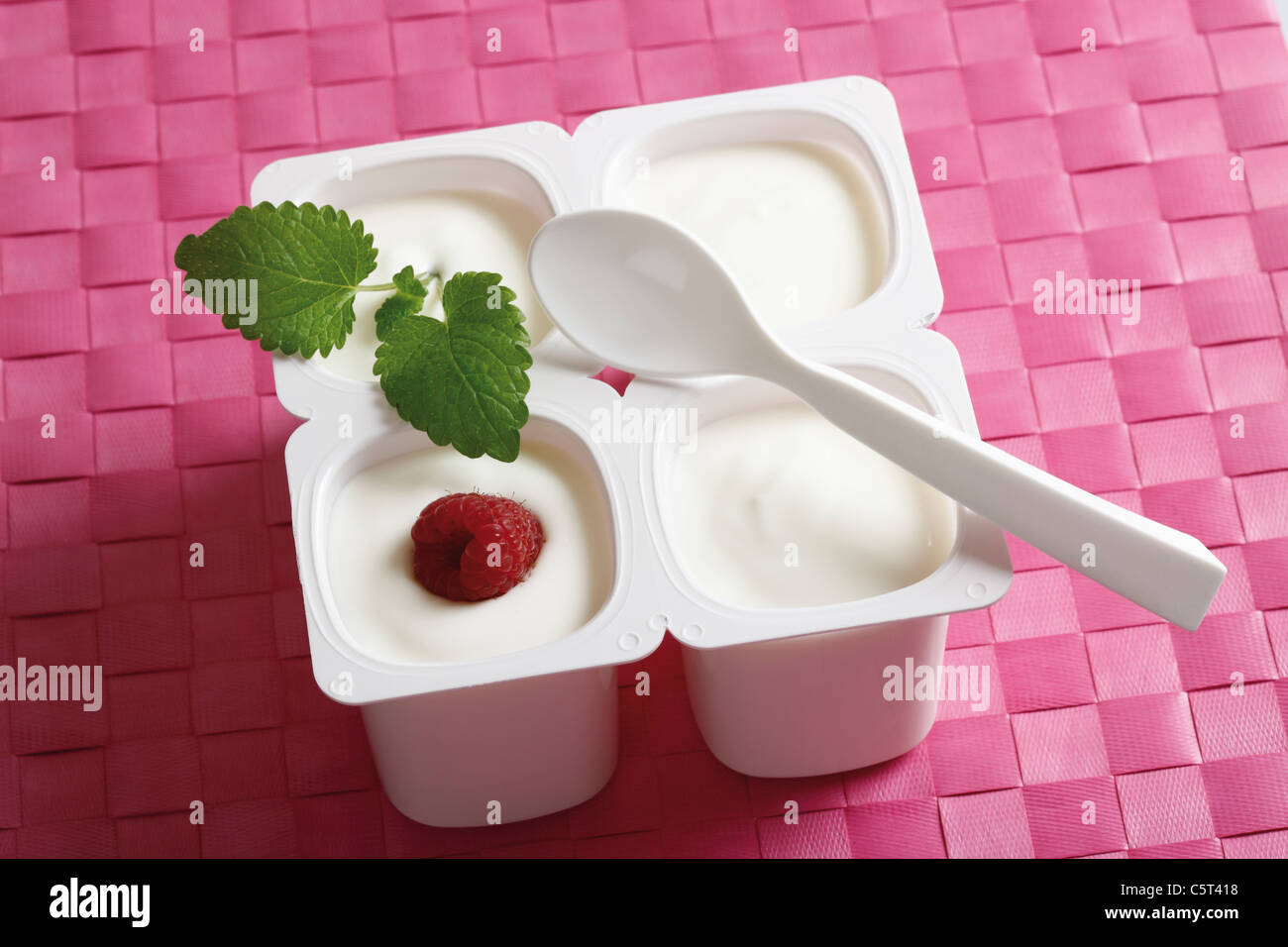 Four open yoghurt cups with fruits hires stock photography and images