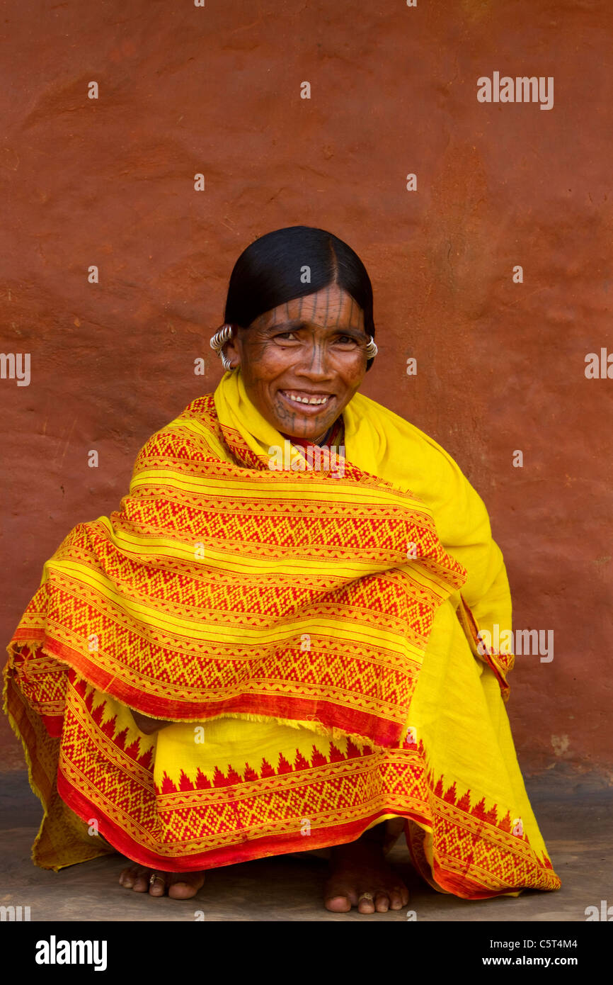 A tribal woman from India sitting in a bright yellow sari Stock Photo