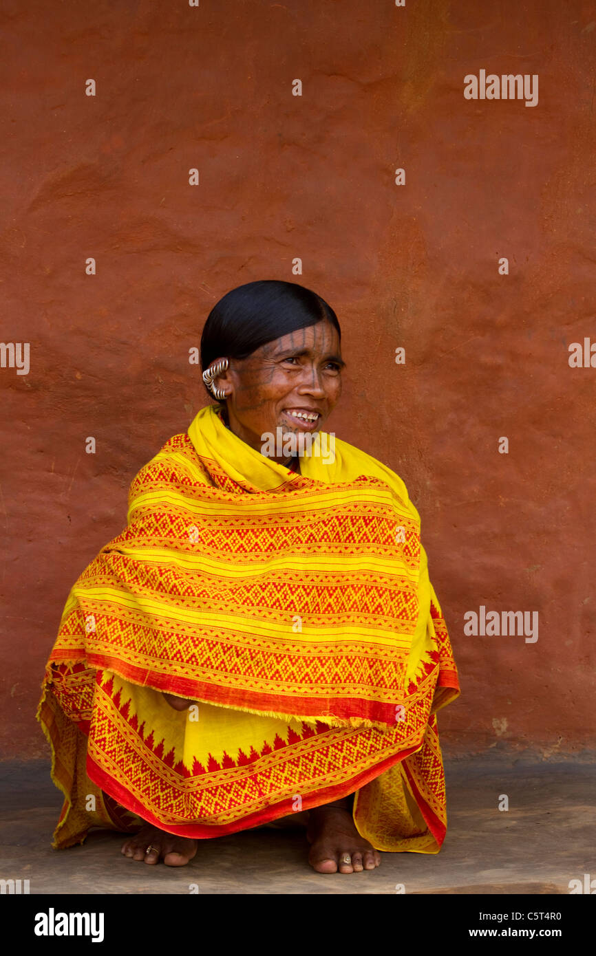 A tribal woman from India sitting in a bright yellow sari Stock Photo