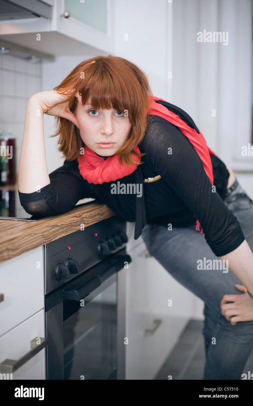 Germany, Young woman in kitchen Stock Photo