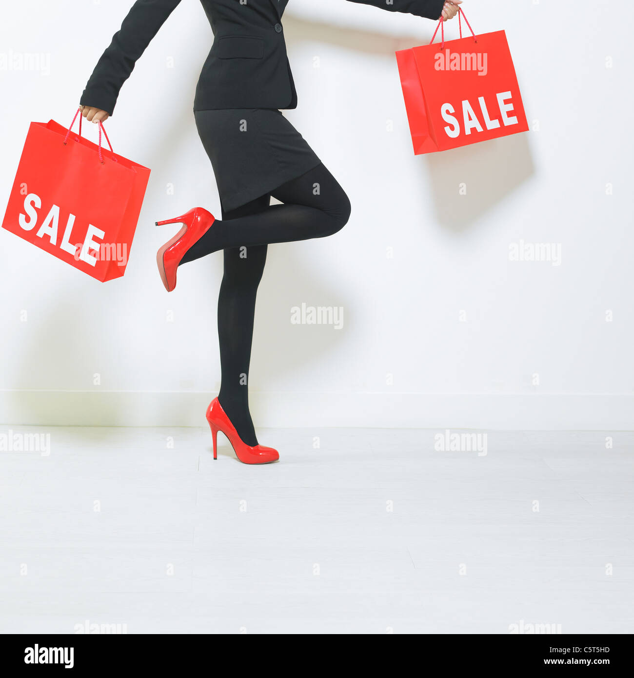 A woman wearing high heels holding shopping bags Stock Photo