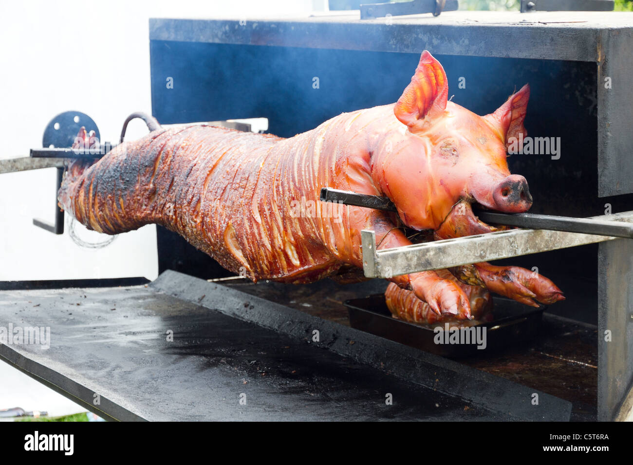 Whole pig on spit being roasted Stock Photo