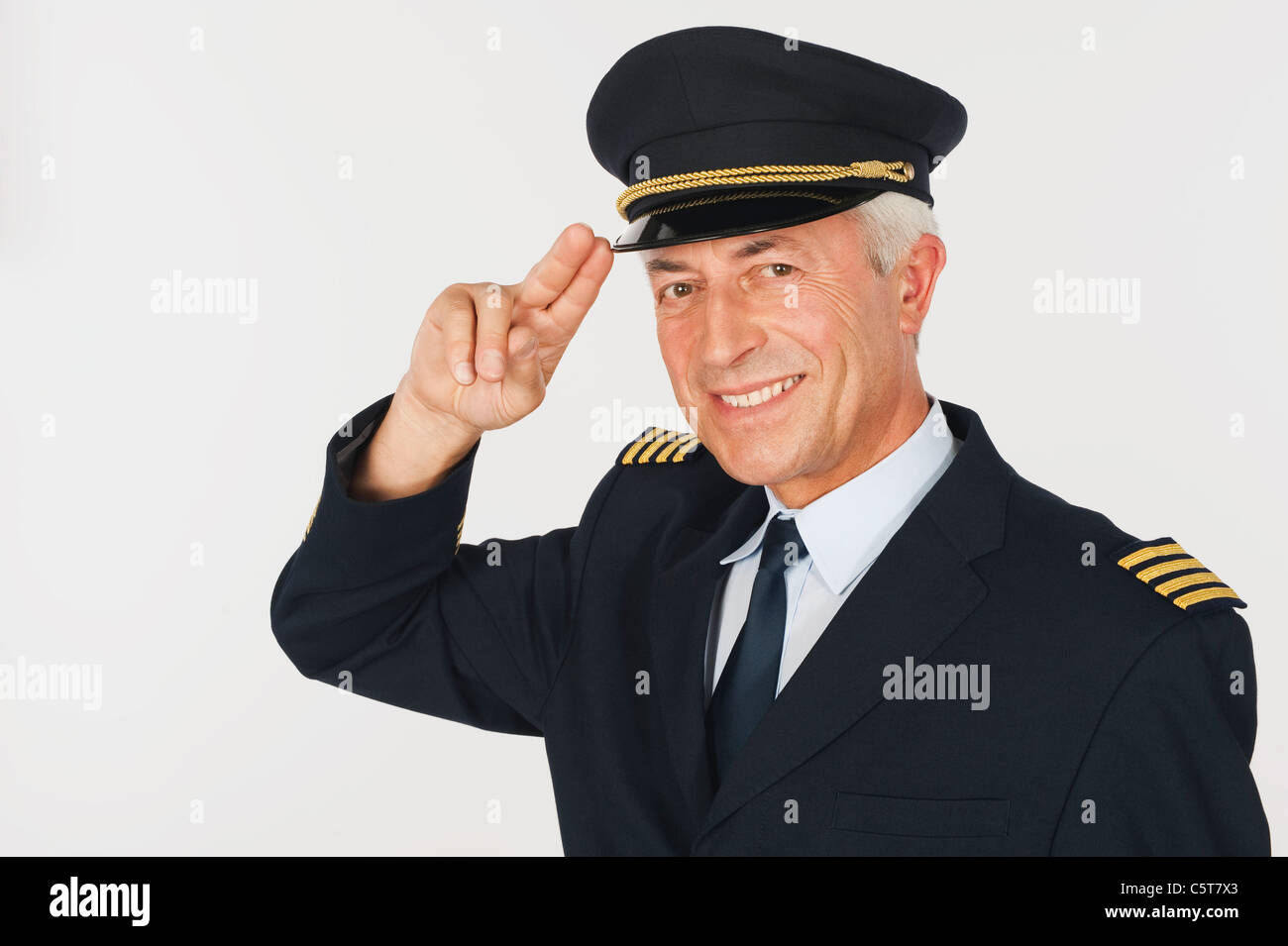 Close up of senior flight captain saluting against white background ...