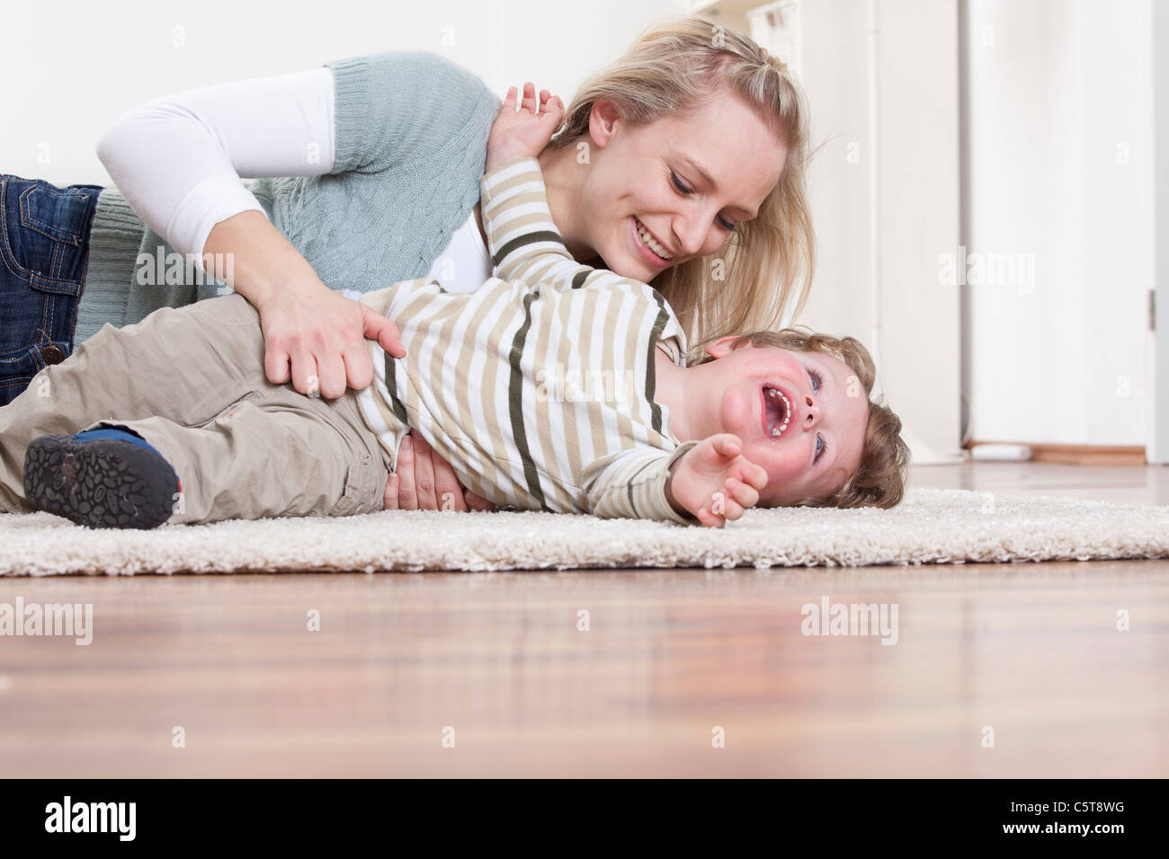 Germany, Bavaria, Munich, Mother and son playing on floor at home Stock Photo