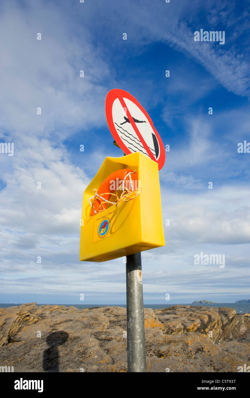 Life belt and warning sign 'no diving' on Malahide beach, Dublin.swimming ring,tube,float,buoyancy aid,buoyant Stock Photo