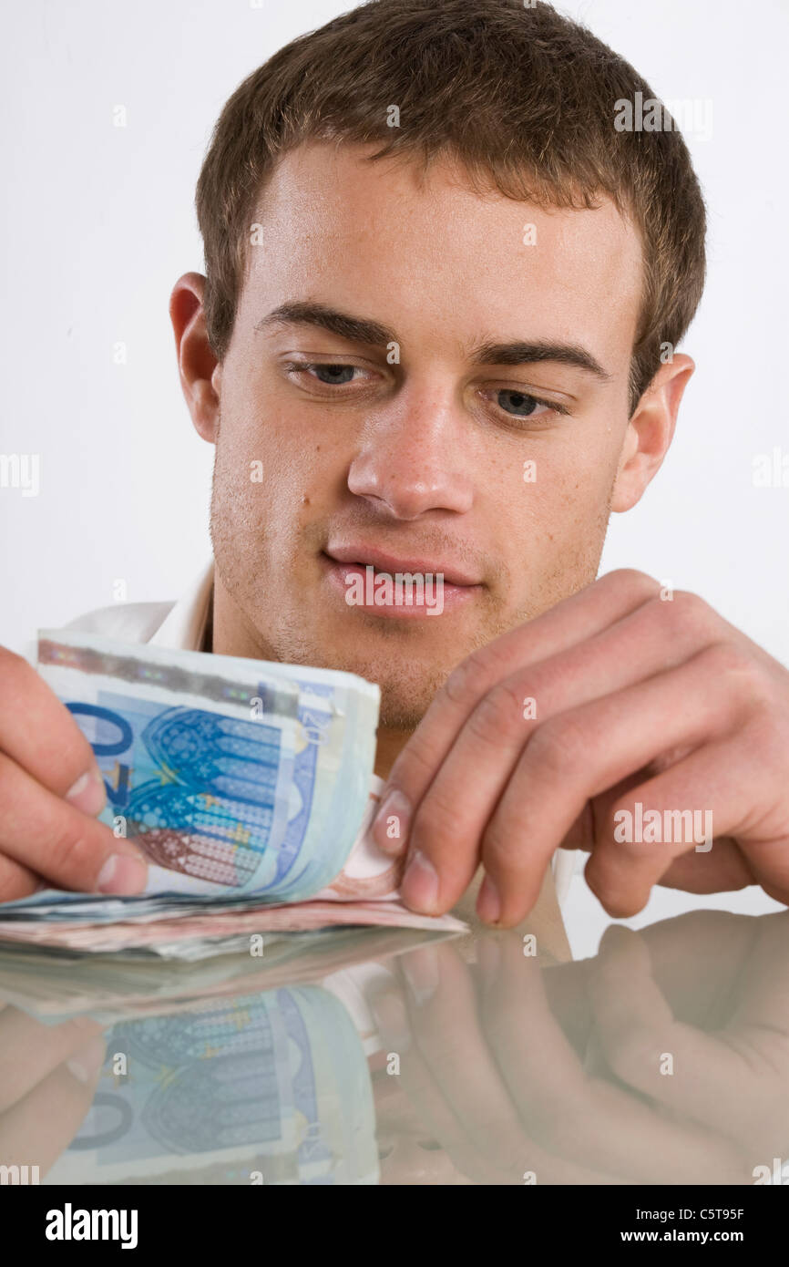 Young man counting Euro notes, portrait Stock Photo