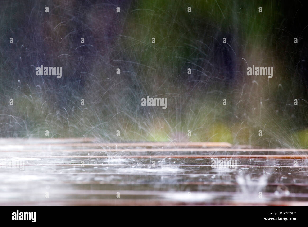 Raindrops hitting a picnic table; Cornwall;UK Stock Photo