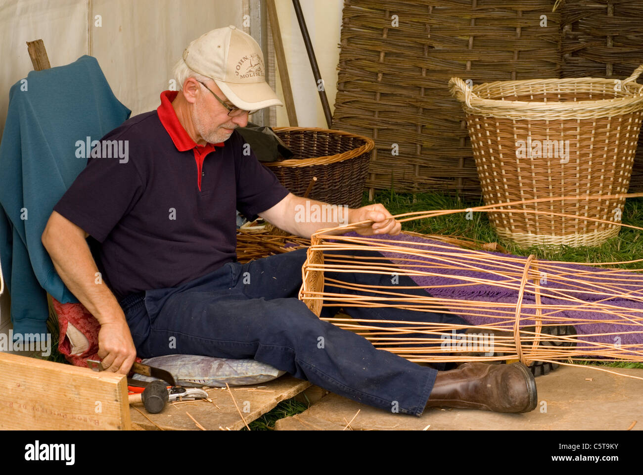 Basket weaver sitting constructing, UK Stock Photo