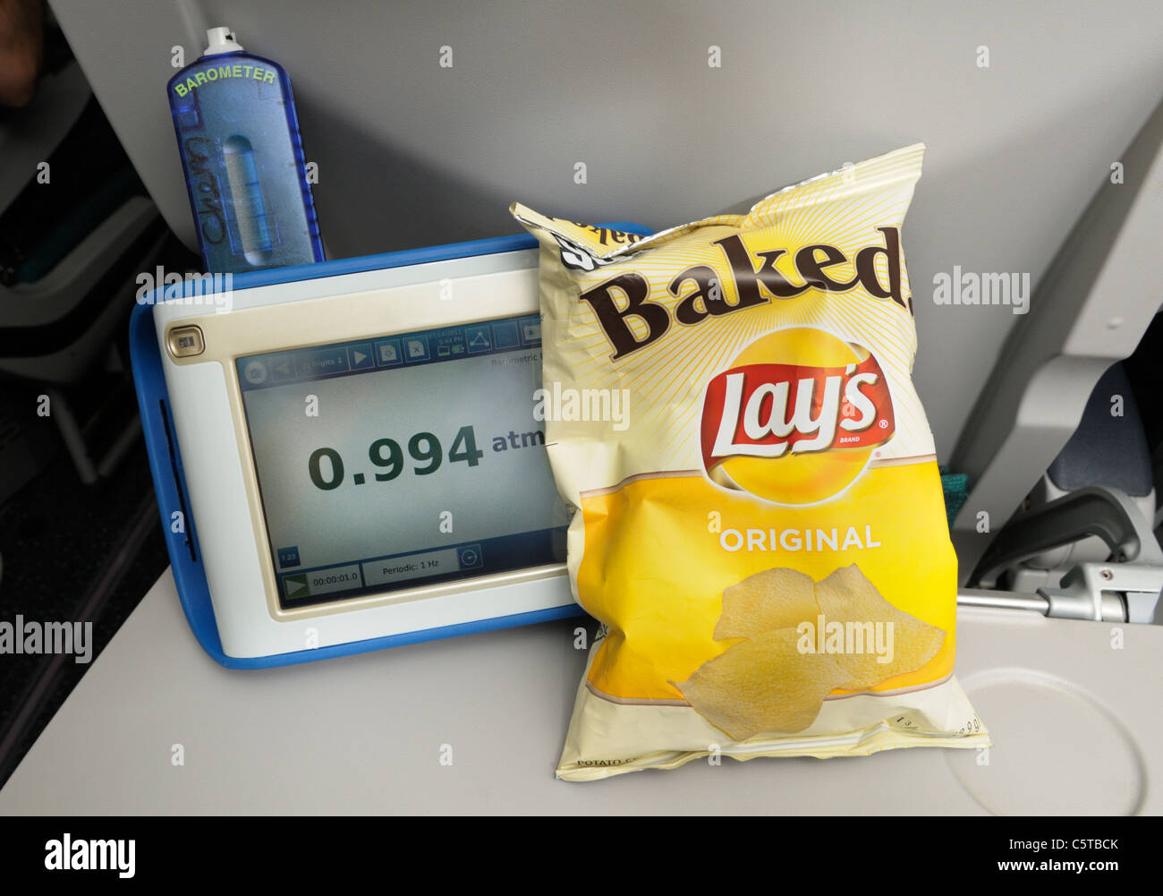 Chip bag on an airplane at sea level. Image # C5TBEA shows the same bag puffed up by lower atmospheric pressure at high altitude Stock Photo