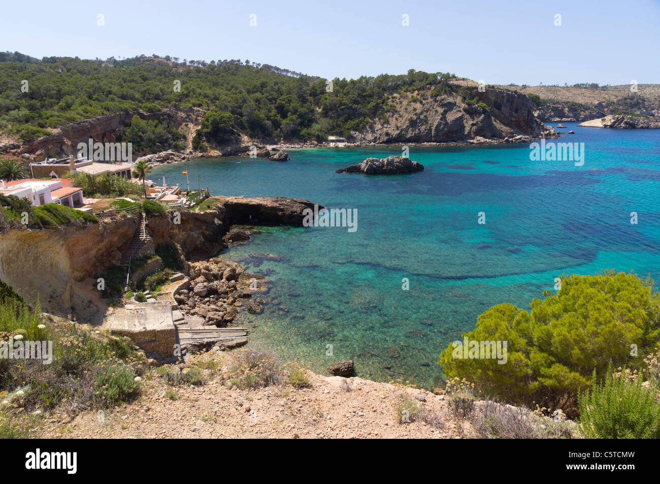 Ibiza, Balearics, Spain - Cala Xarraca, rocky inlet and bay with beach, rocks and woodlands Stock Photo