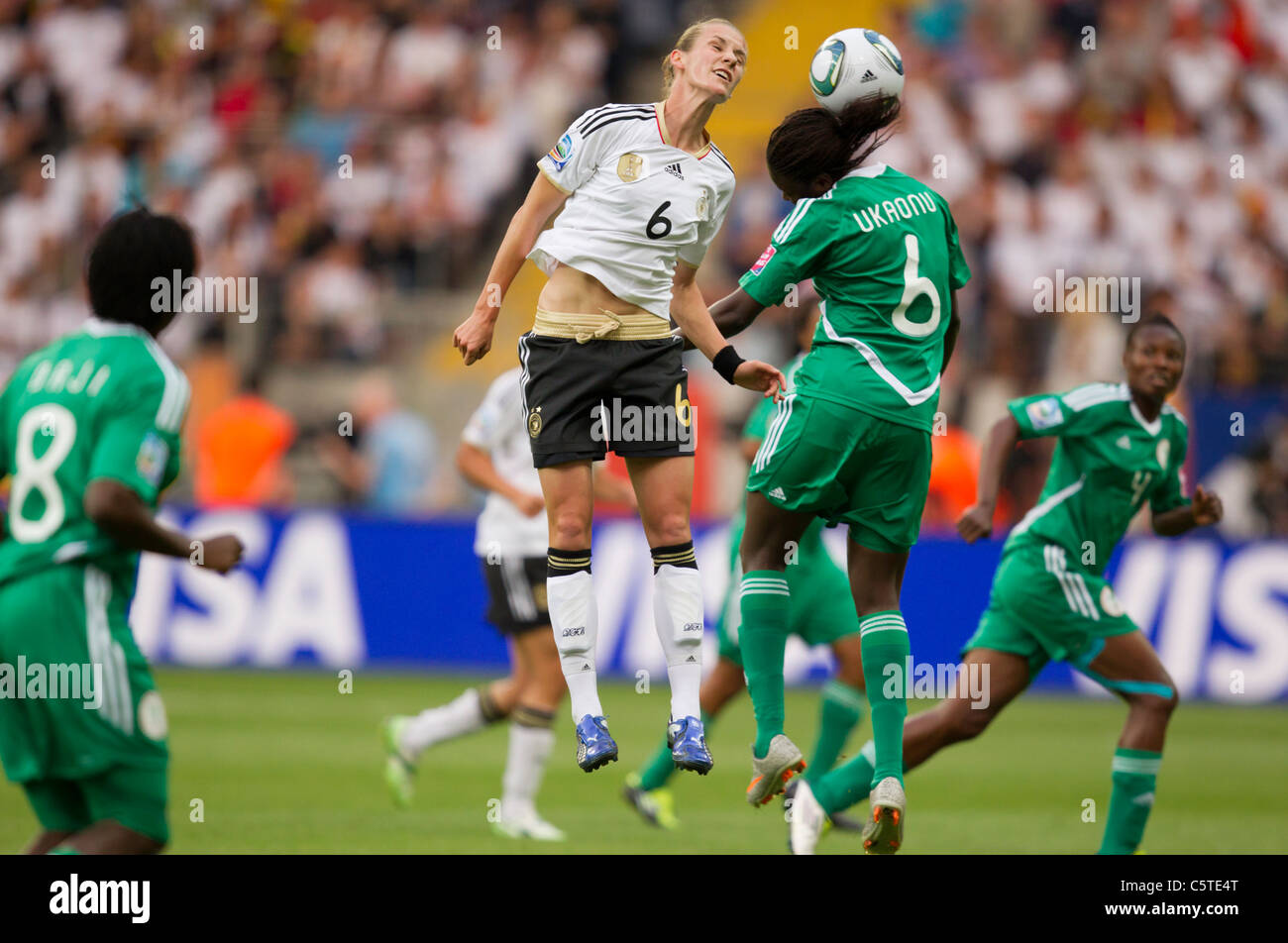 Simone Laudehr of Germany (l) and Helen Ukaonu of Nigeria (r) battle for a header during a 2011 FIFA Women's World Cup match. Stock Photo