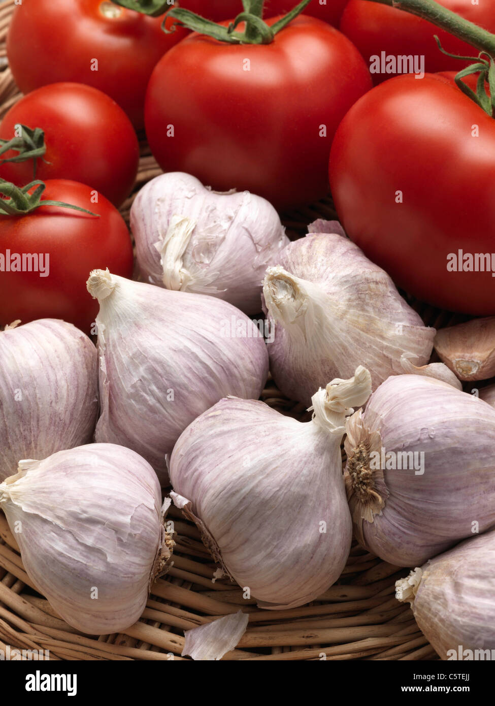 A wicker basket of garlic and ripe red tomatoes Stock Photo - Alamy