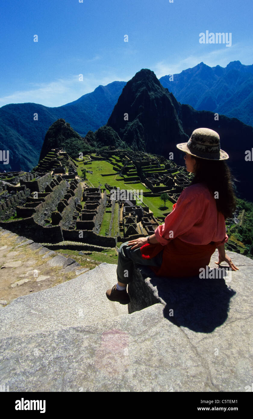 Mestizo girl at Machu Picchu ruin viewing Haina Picchu peak in Peru Stock Photo
