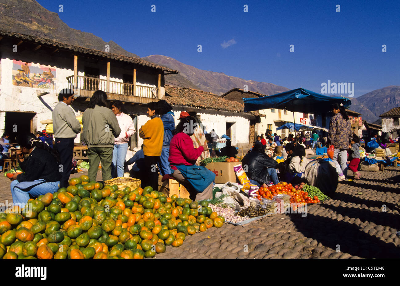 Oranges for sale at the weekend marked in Pisac town, Peru. People on the square. Stock Photo