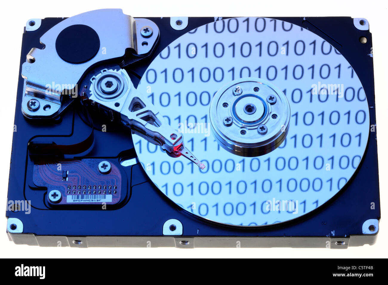 Computer hard drive, opened, writing/reading head and hard disk. Binary code numbers are reflecting on the hard disc. Symbol. Stock Photo