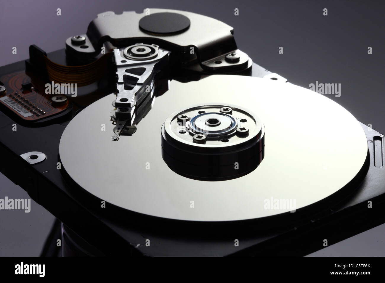 Computer hard drive, opened, reading/writing head and hard disk. Stock Photo