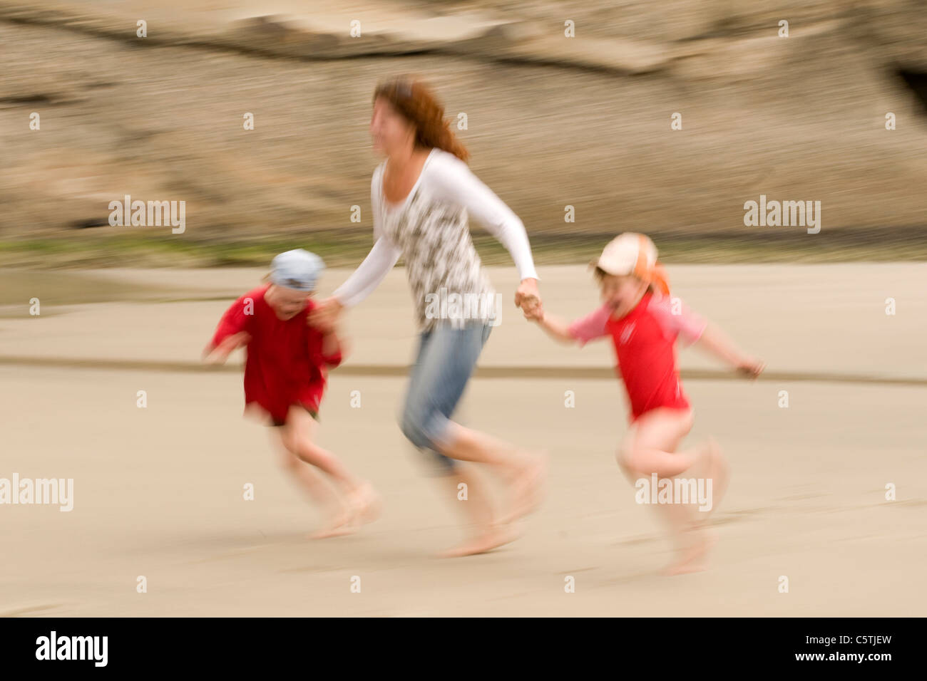 New Zealand, Cape Farewell, Woman with children (4-5) (6-7) on the beach, having fun Stock Photo
