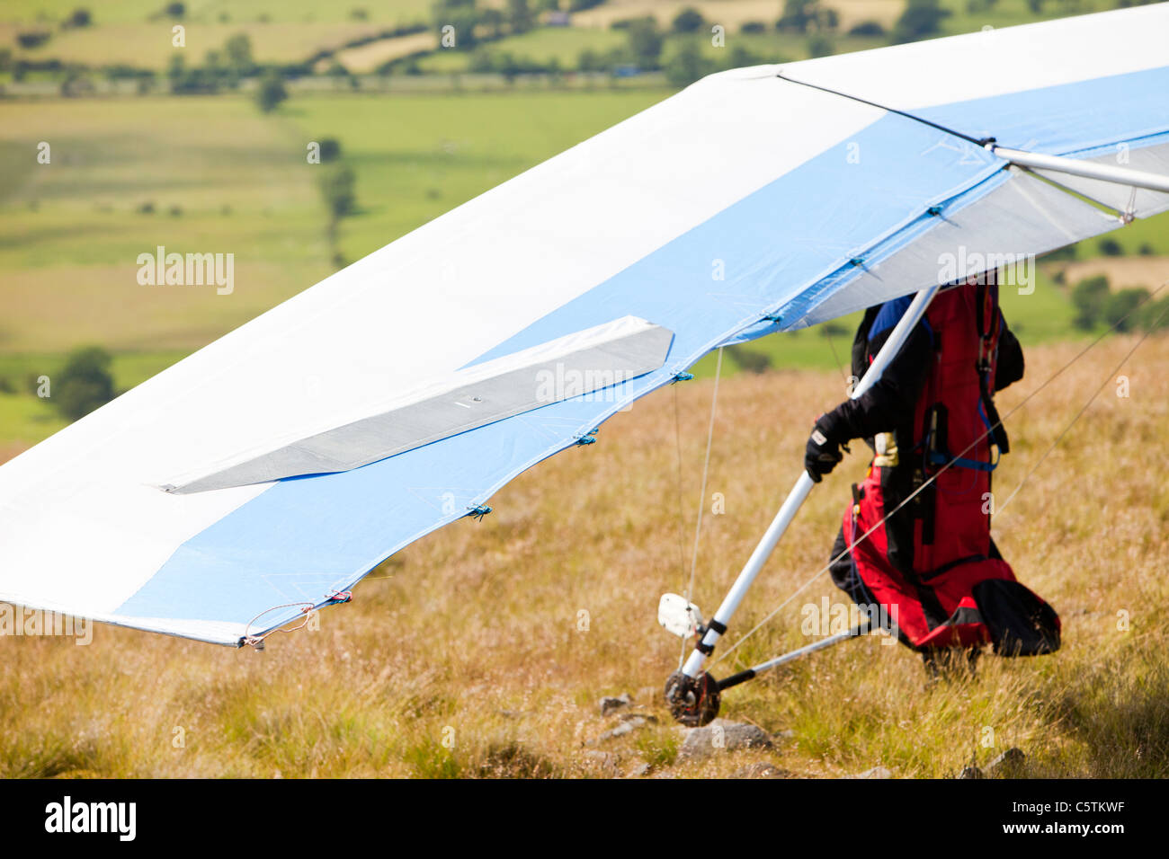 A hangglider flying from the side of Pendle Hill, above Clitheroe in Lancashire, UK. Stock Photo