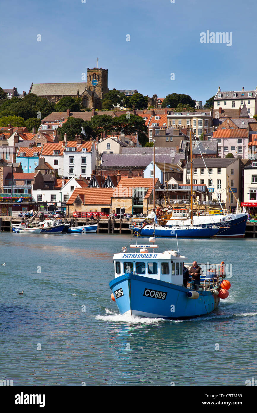 Fishing boat leaving Scarborough Harbour, North Yorkshire Stock Photo