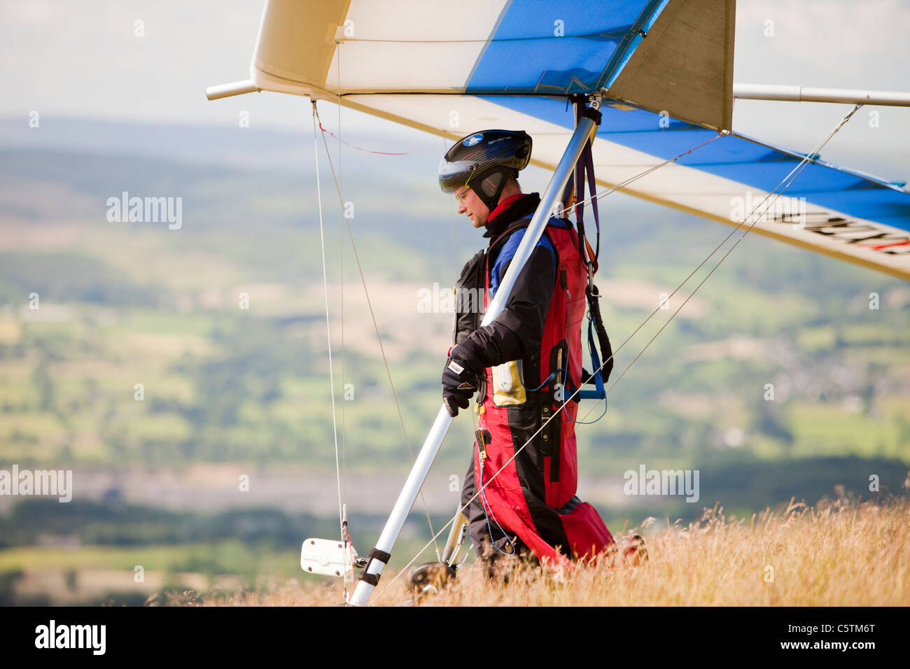 A hangglider flying from the side of Pendle Hill, above Clitheroe in Lancashire, UK. Stock Photo