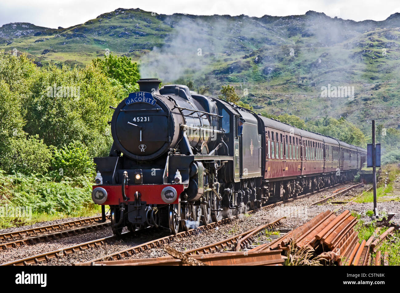 The Jacobite steam train approaches Arisaig railway station at Arisaig in the West Highlands of Scotland Stock Photo