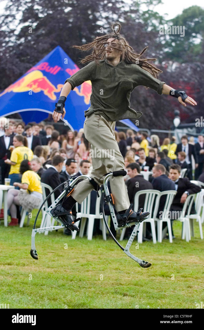 Dreadlocked young man wearing stilt walkers which enable the wearer to