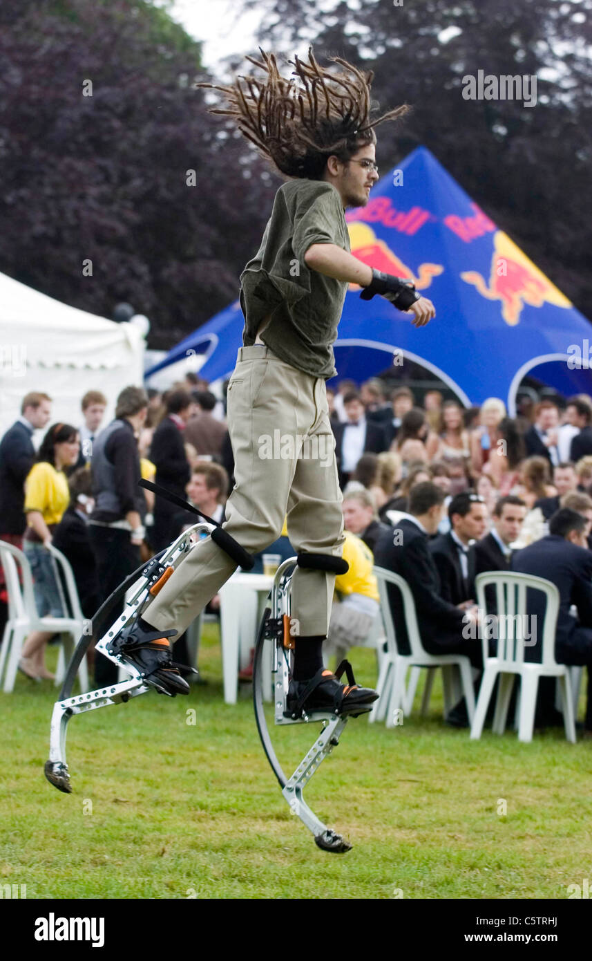 Dreadlocked young man wearing stilt walkers which enable the wearer to