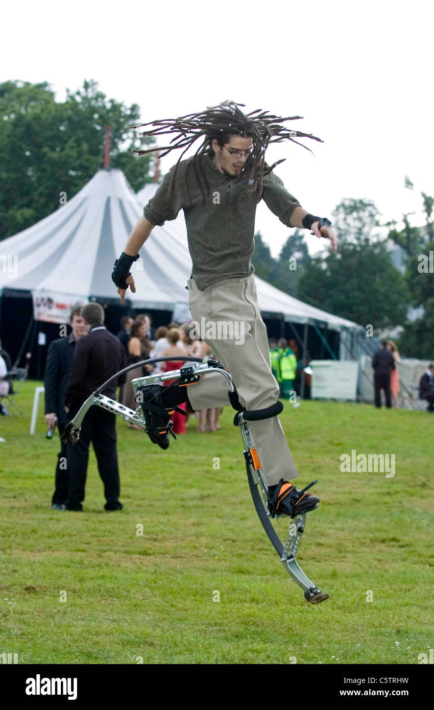 Dreadlocked young man wearing stilt walkers which enable the wearer to