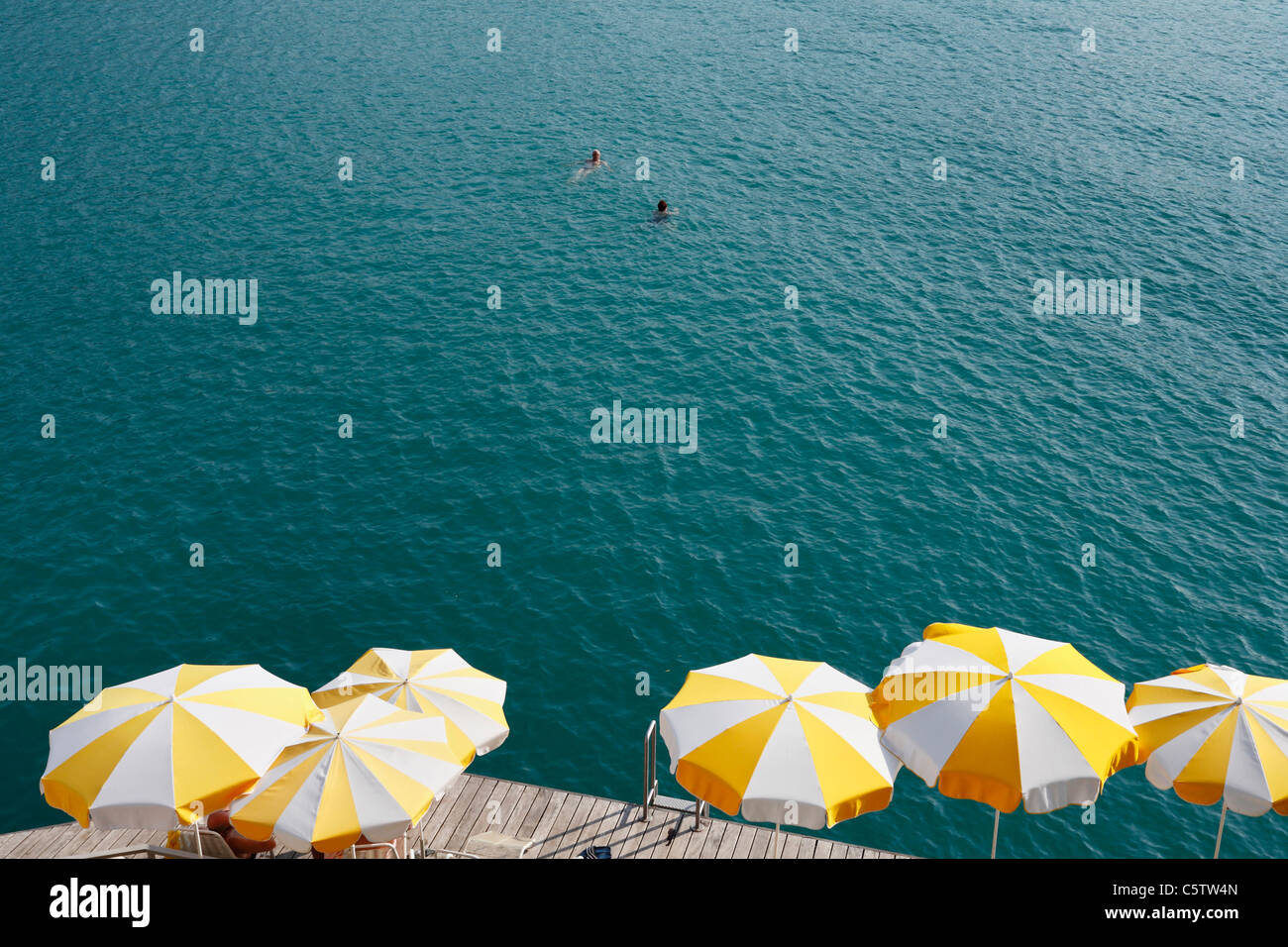 Austria, Upper Austria, Salzkammergut, View of beach umbrellas and pier near Wolfgangsee lake Stock Photo