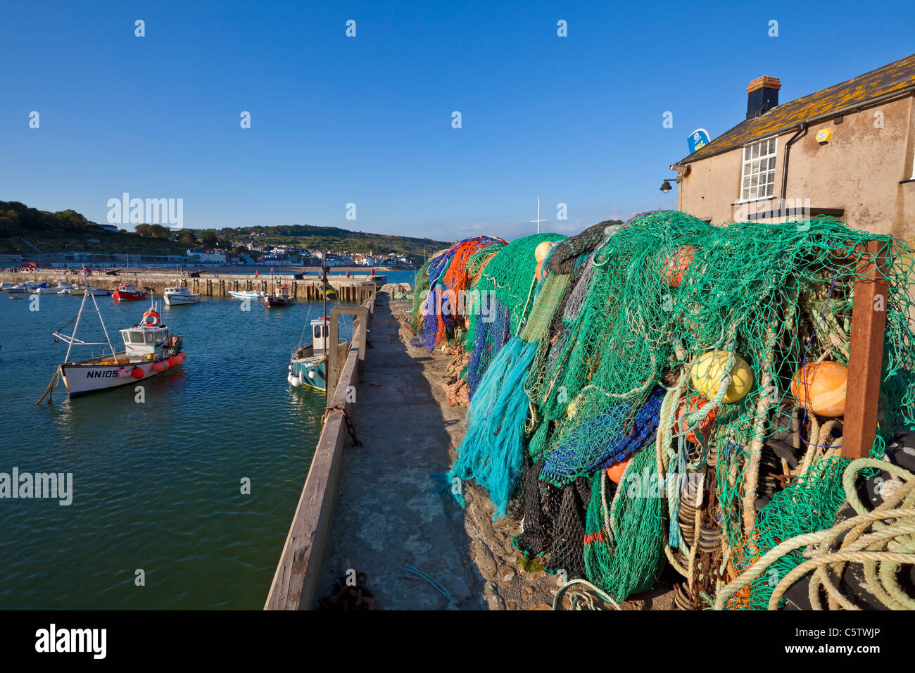 Fishing nets and floats on the harbour wall in Lyme Regis harbour Dorset England UK GB EU Europe Stock Photo
