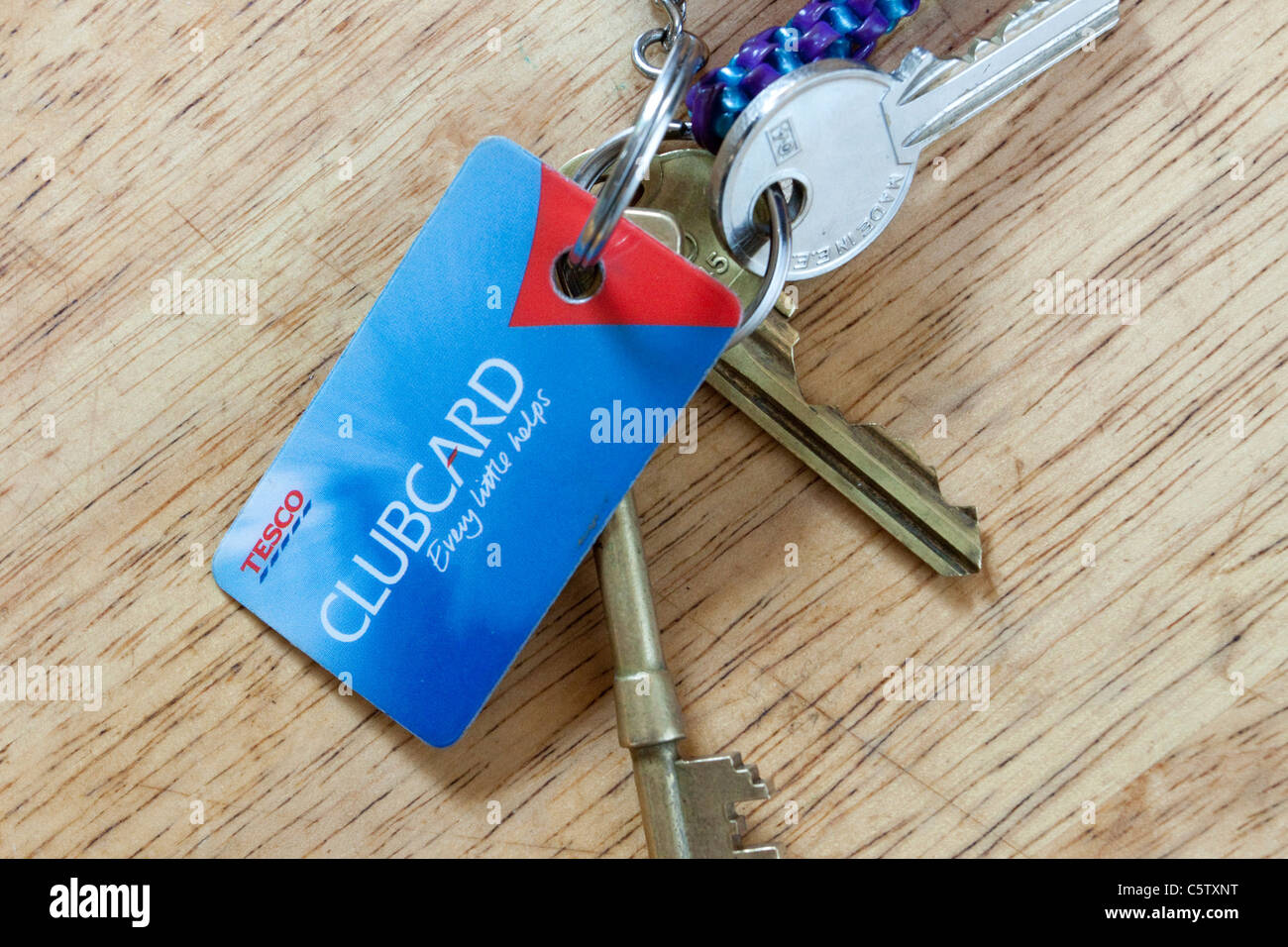 Tesco clubcard on a keyring with a bunch of keys on a wooden table, England, UK Stock Photo