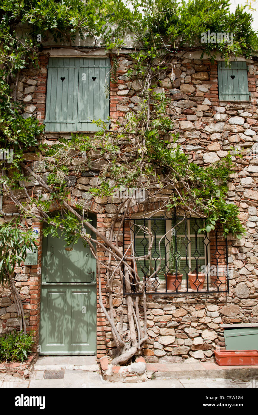Grimaud, Var Cote d'Azur, France. Stony house front with light green shutters and door Stock Photo