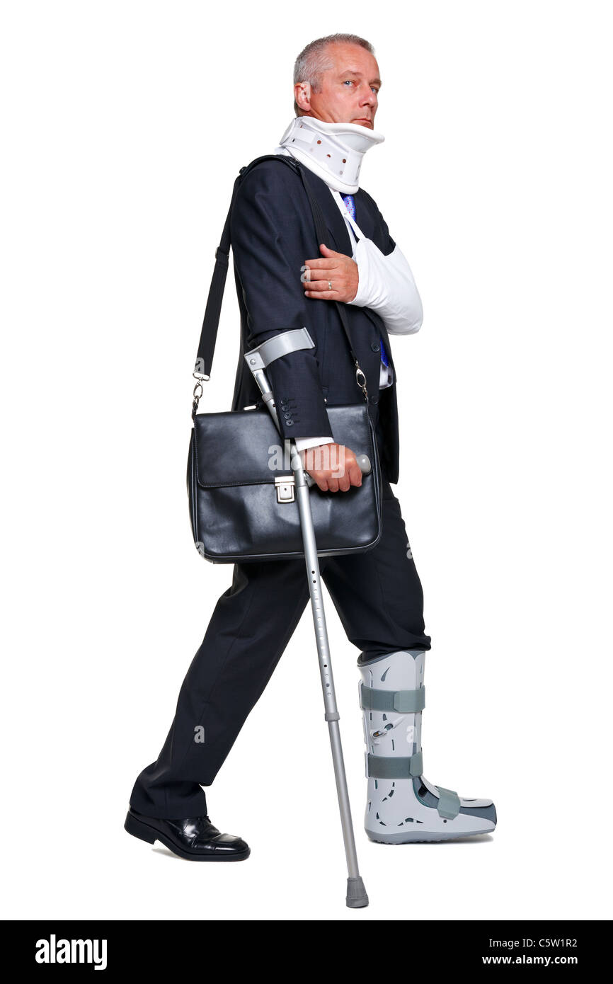 Photo of a badly injured businessman walking on cructhes carrying a briefcase, isolated on a white background. Stock Photo