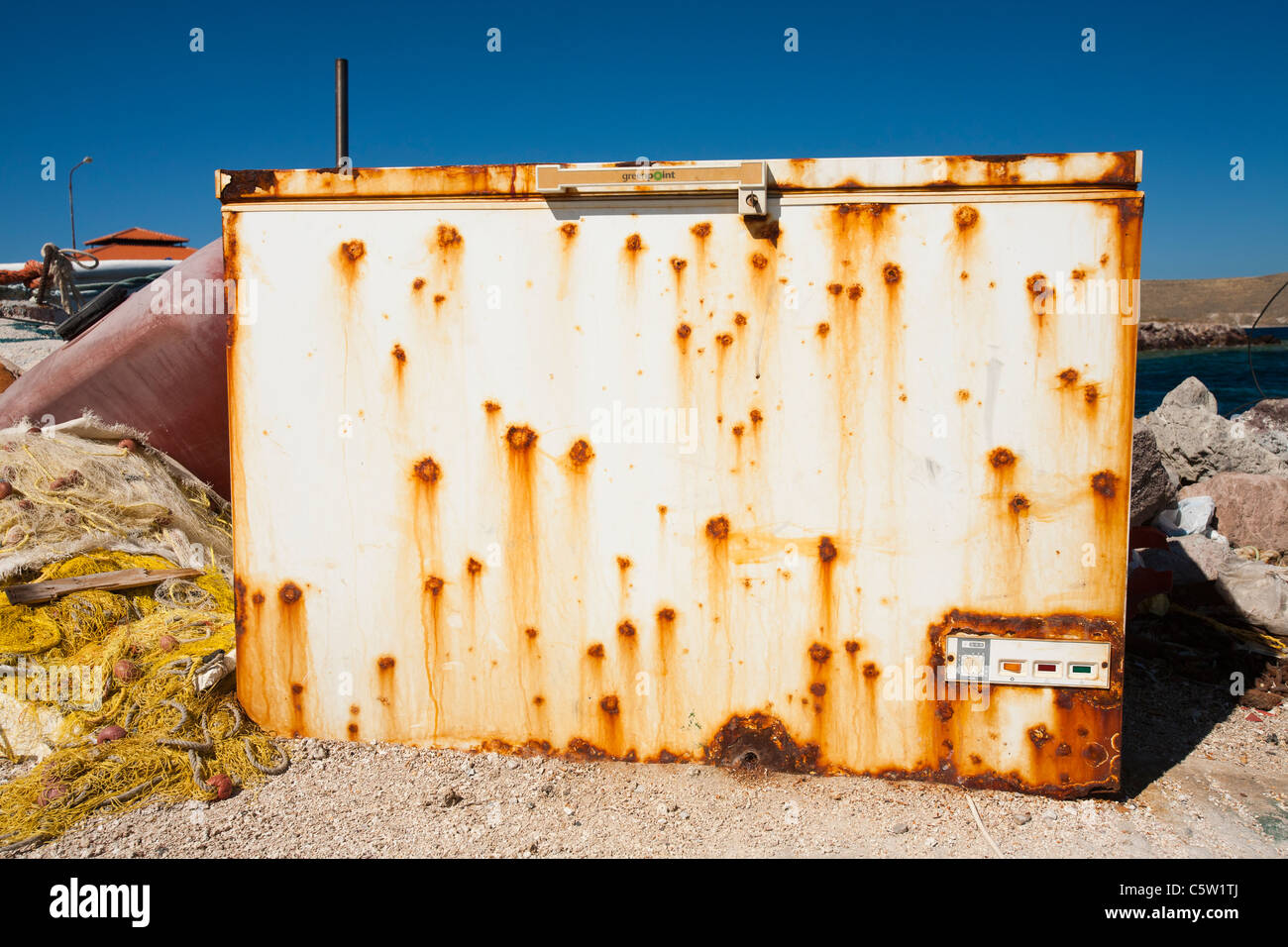 An old rusting chest freezer on the harbour side at Sigri, Lesbos, Greece. Stock Photo
