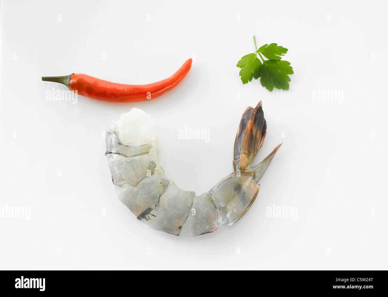 Raw prawn, cilantro and chili pod, elevated view Stock Photo