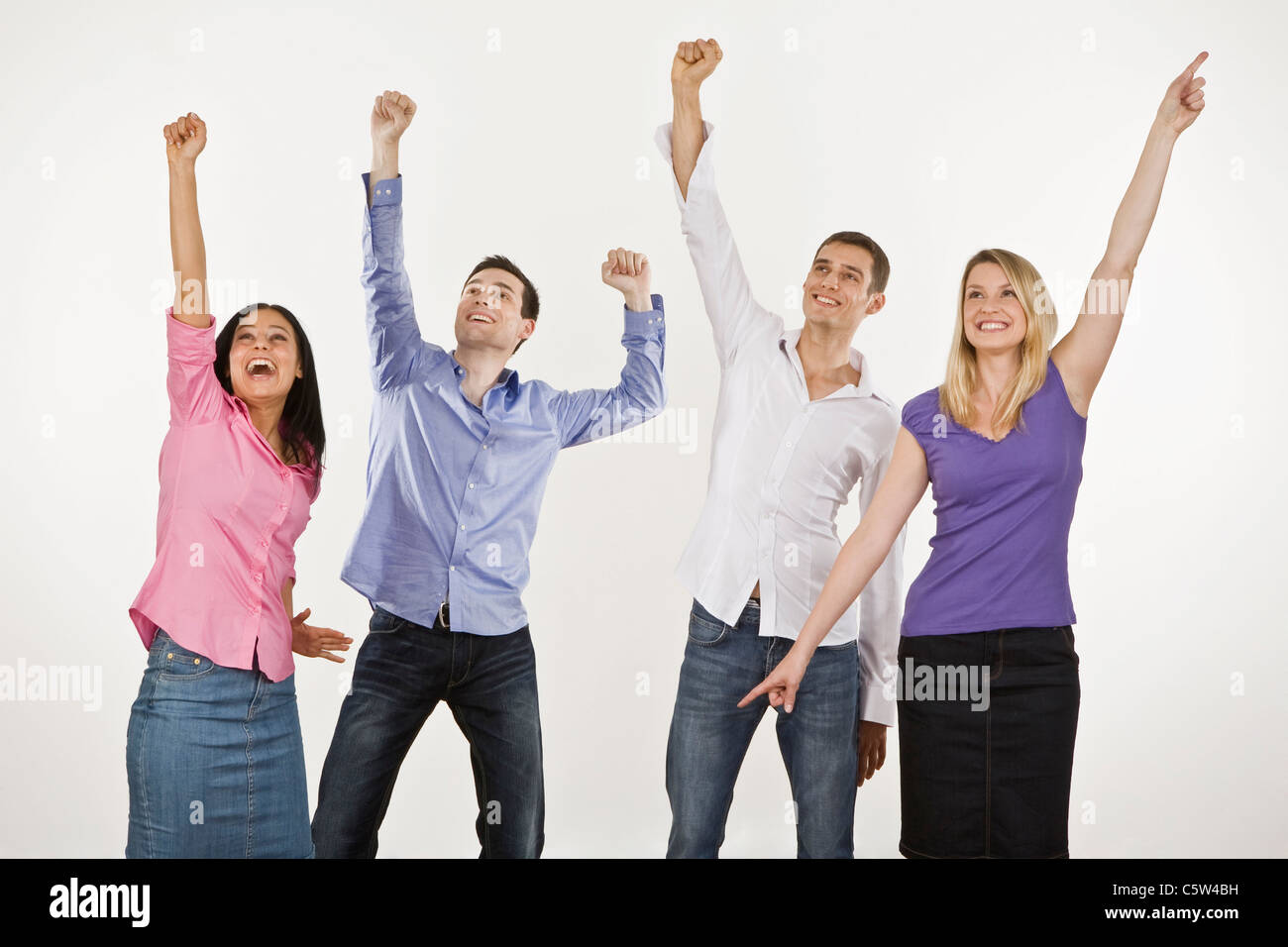 Four persons cheering, hands up Stock Photo