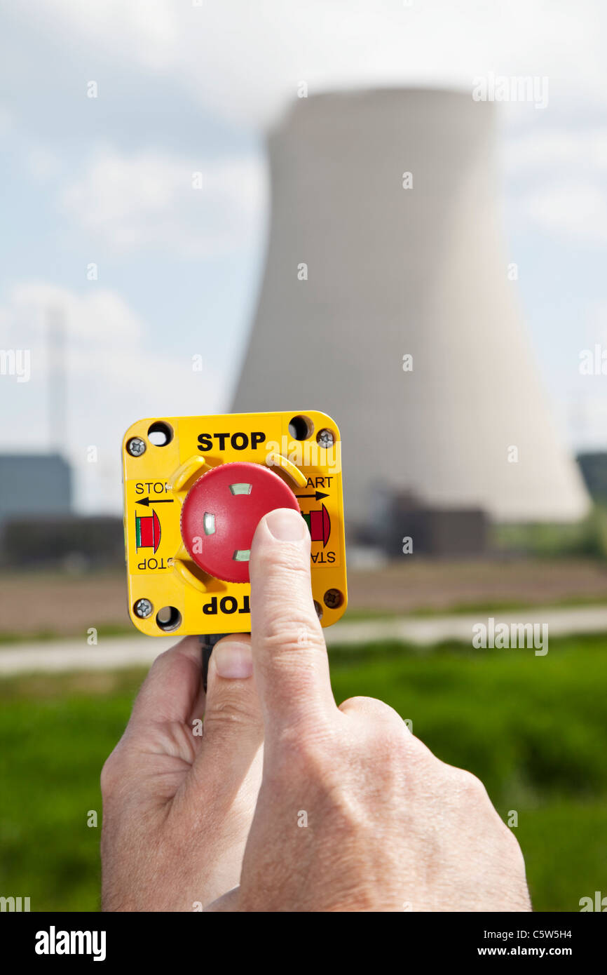 Germany, Bavaria, Unterahrain, Hand of man pressing shut off button near AKW Isar Stock Photo
