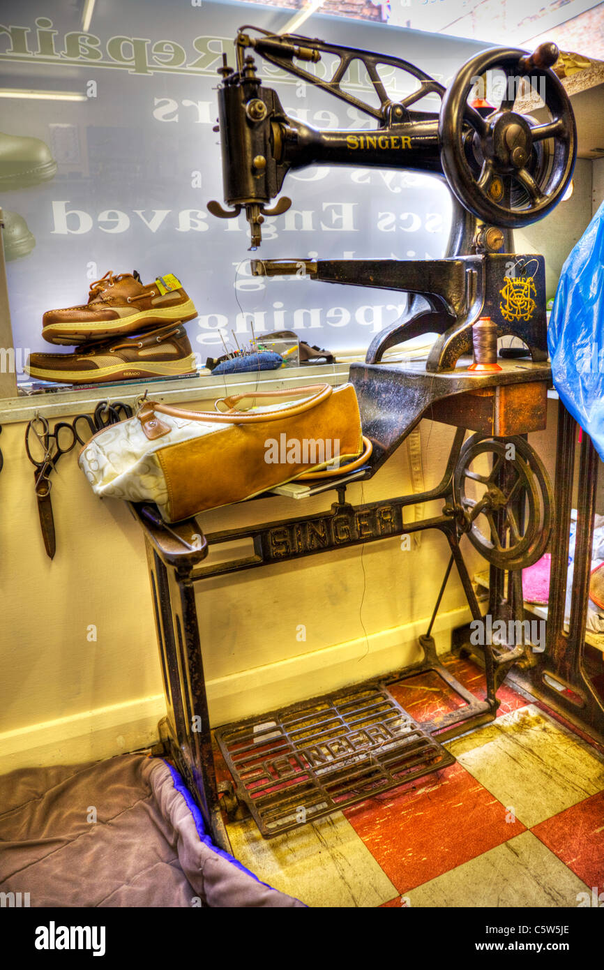 HDR image of a singer sewing machine in a cobblers shop with work waiting to be repaired, shoe repairers, bag, shoes, antique Stock Photo