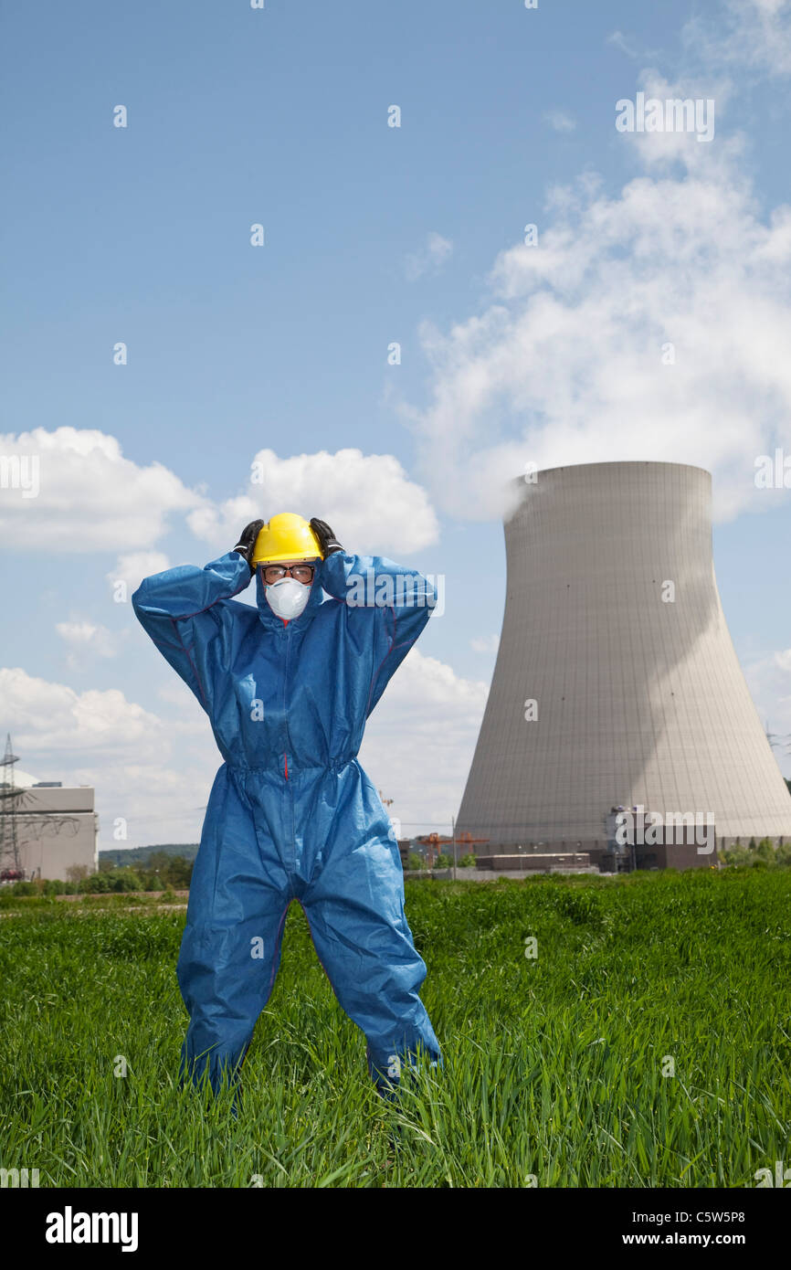 Germany, Bavaria, Unterahrain, Man with protective workwear standing in field at AKW Isar Stock Photo